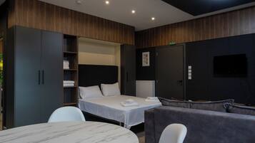 Una habitación de hotel moderna con una cama, un sofá, una mesa y un televisor.