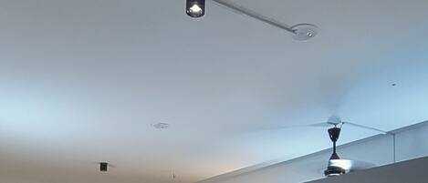 A room with a ceiling fan, a door, and a wall unit with multiple compartments.