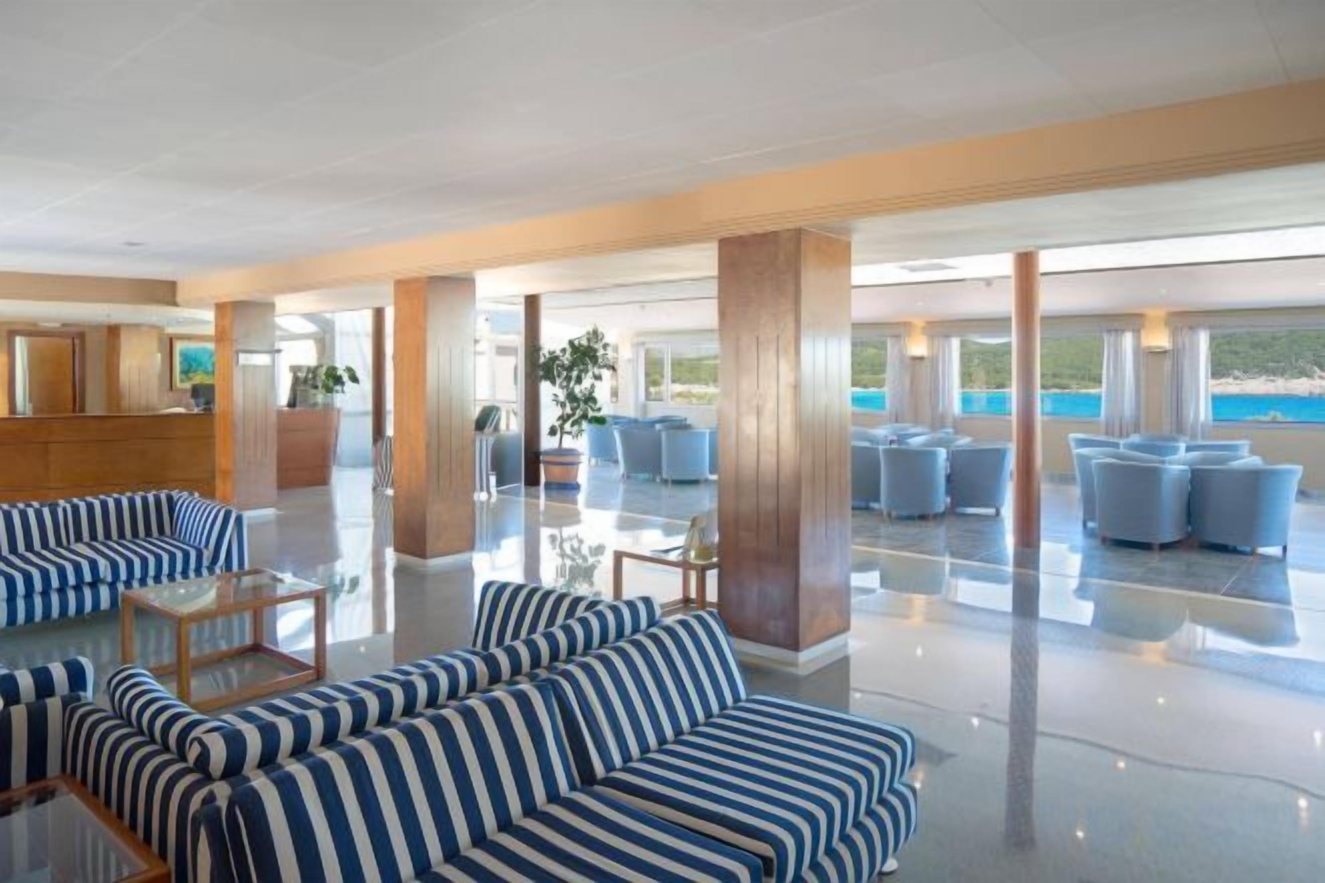 Un hall d’entrée spacieux avec un comptoir de réception, des coins salon et une vue sur la mer.