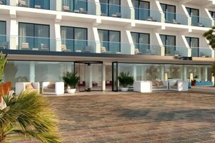 Un hotel moderno con un amplio espacio de esparcimiento al aire libre, grandes ventanales y un diseño de techo plano.