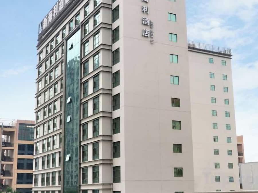 A multi-story hotel building with a modern facade, featuring a series of windows and balconies.