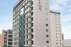 A multi-story hotel building with a modern facade, featuring a series of windows and balconies. - Xinhaili Hotel (Zhuhai)