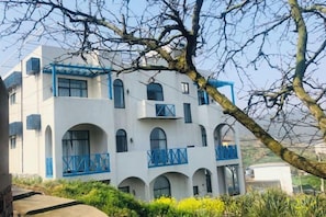 A multi-story building with balconies and arched windows. - Shengsi Blue Castle Scenic Apartment (Liujingtan) (Shengsi)