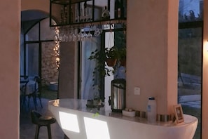 A bar area with a curved counter, a hanging light fixture, and a potted plant. - Shengsi Blue Castle Scenic Apartment (Liujingtan) (Shengsi)