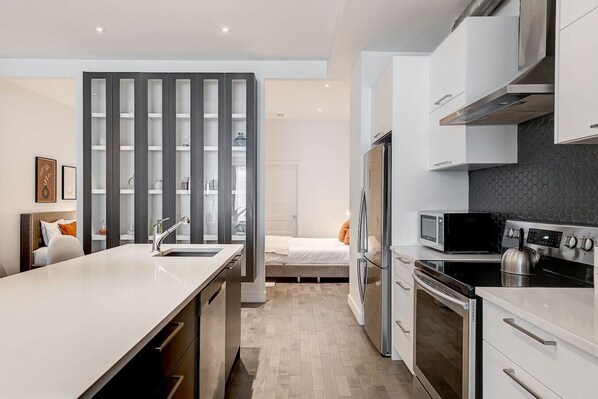 Una cocina moderna con una isla central, electrodomésticos integrados y una zona de comedor independiente.
