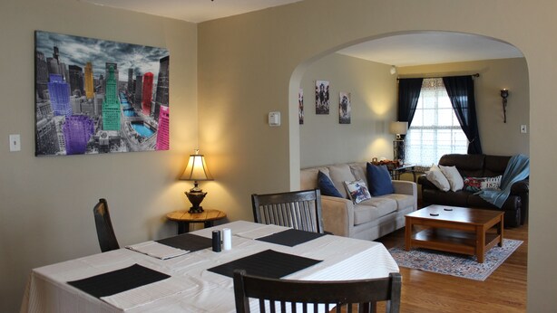 A living room with a dining area, a sofa, a coffee table, and a lamp.
