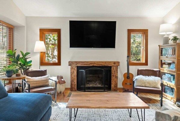 A living room with a fireplace, a television, and a bookshelf.