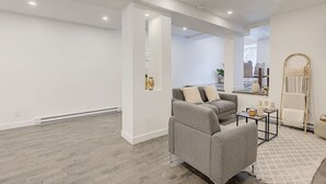 Un salon moderne avec un canapé gris, une table basse et un tapis à motifs.