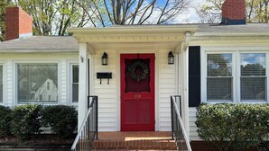 A two-story house with a red front door, a mailbox, and a number 413 on the door.