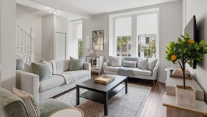 Ein modernes Wohnzimmer mit zwei Sofas, einem Couchtisch und einem Fernseher.
