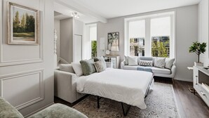 Ein Schlafzimmer mit einem Bett, zwei Sofas, einem Nachttisch und einem Fenster mit Blick.