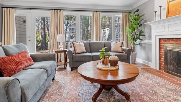 A living room with two grey sofas, a round coffee table, and a fireplace.