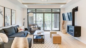 A modern living room with a sofa, coffee table, and a fireplace.