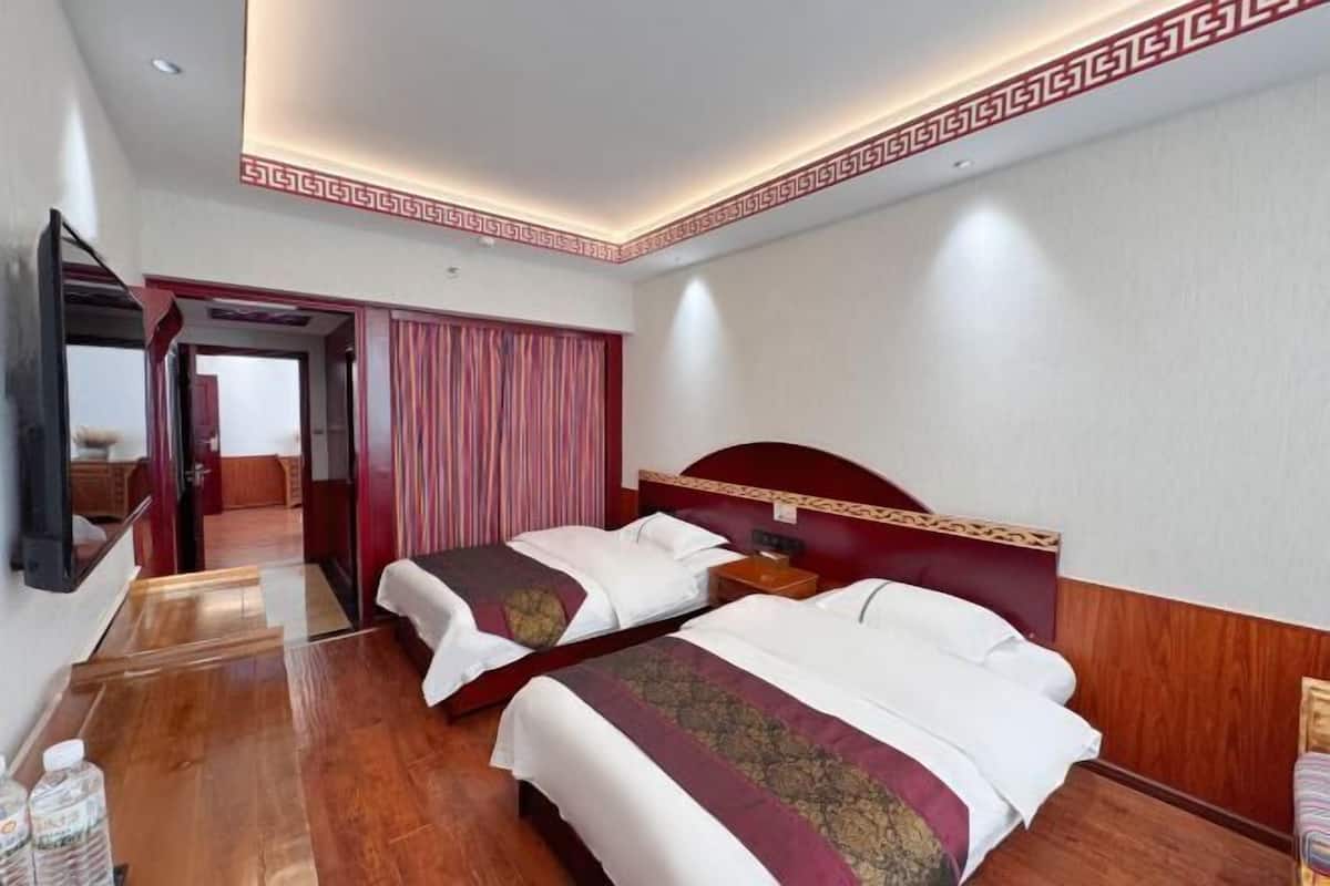 Une chambre d’hôtel avec deux lits, une télévision et un miroir.