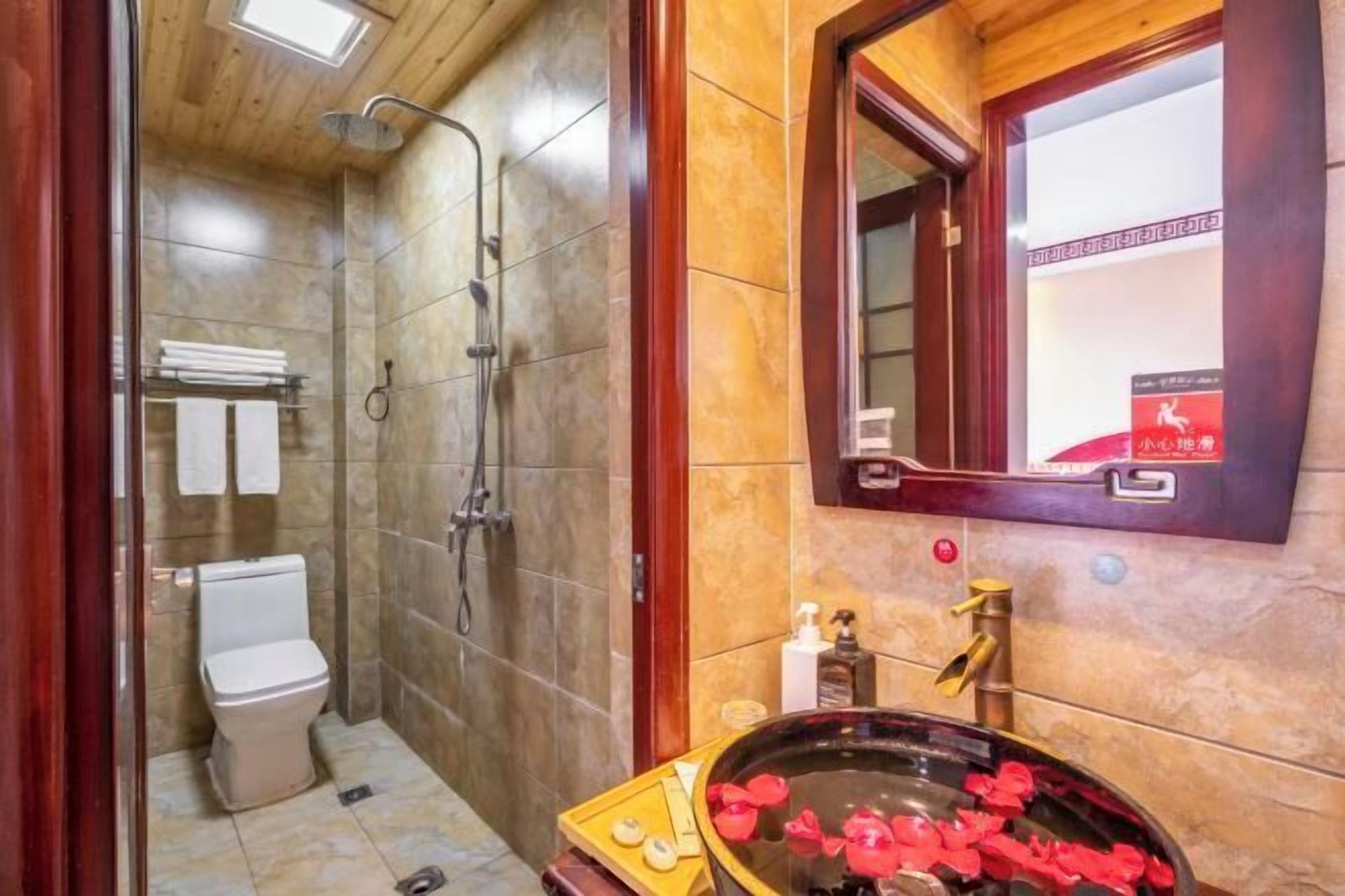 Une salle de bain comprenant des toilettes, une douche et un lavabo agrémenté d’un receveur décoratif.