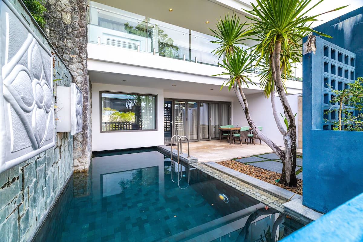 Una casa moderna con piscina, balcón y zona de patio.
