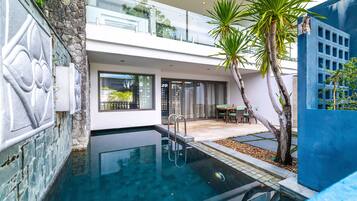 Ein modernes Haus mit Schwimmbad, Balkon und Terrassenbereich.