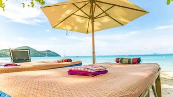 Relax in comfort under a spacious umbrella, surrounded by the soothing sounds of the ocean.
