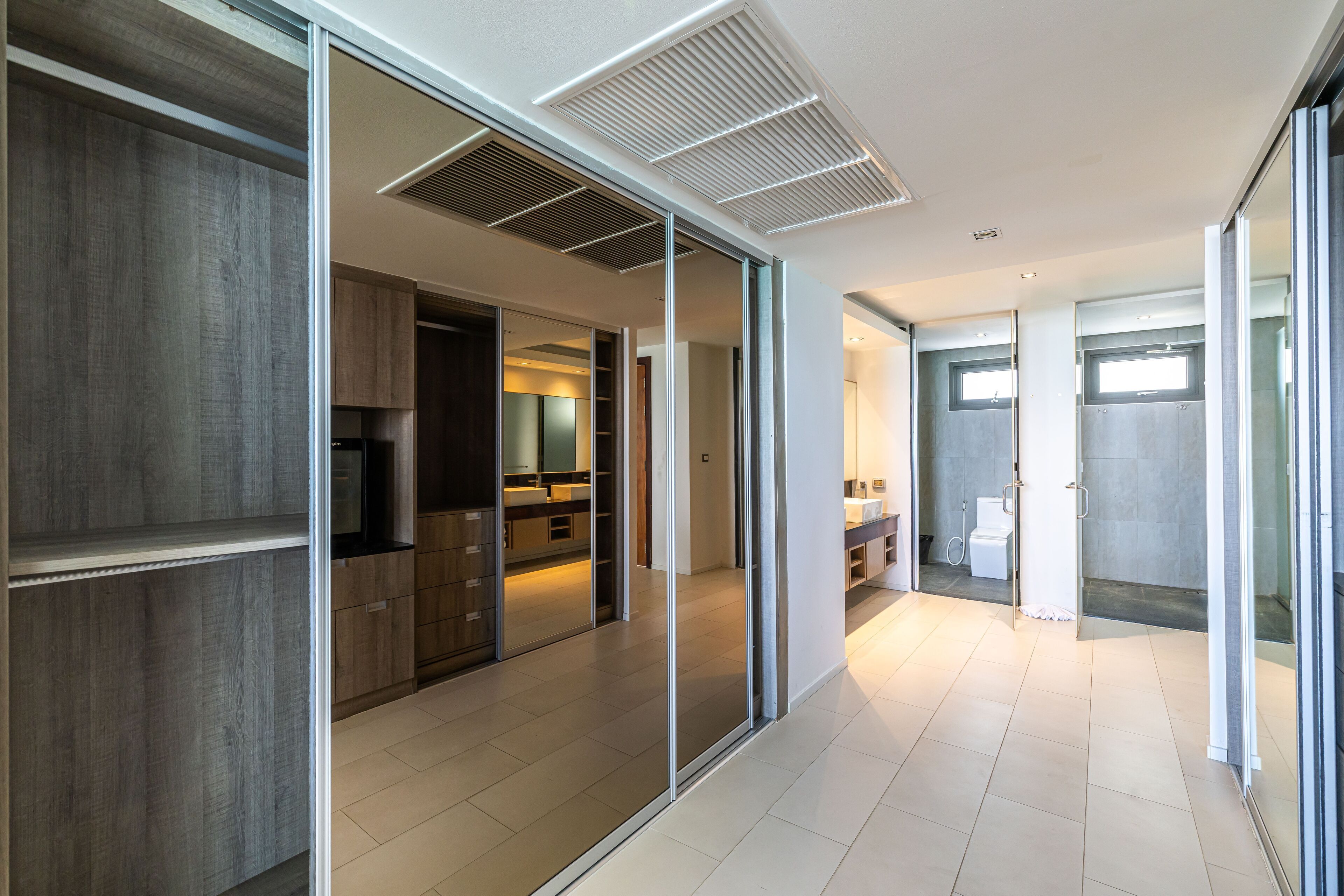 Een modern interieur met schuifdeuren naar een keuken en badkamer, met een strak, minimalistisch design.