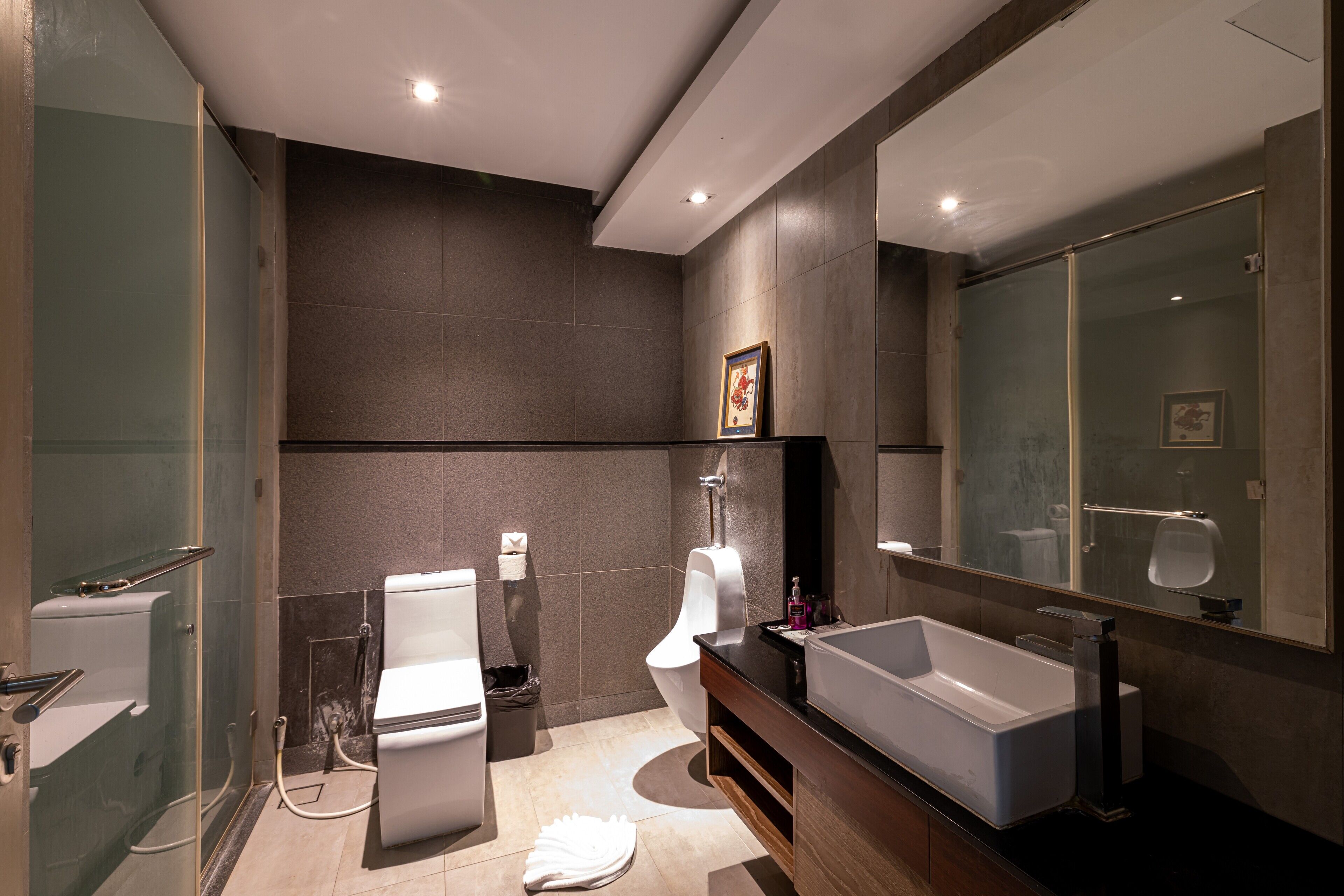 Een moderne badkamer met een douche met glazen wand, toilet, bidet en een ruime badkuip.