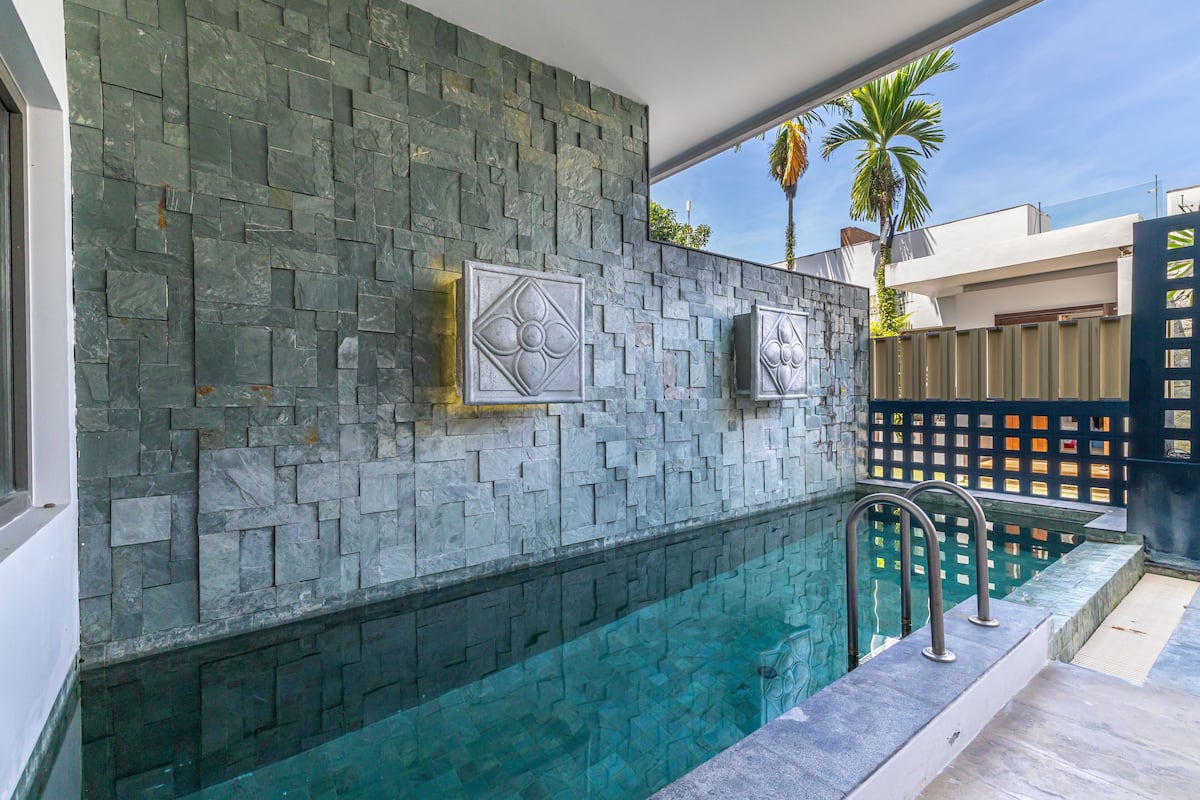 Una piscina con un muro de piedra y dos paneles decorativos.