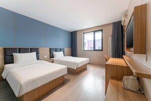 Una habitación de hotel con dos camas, un escritorio y una televisión.