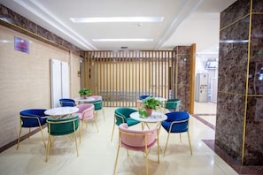 A hotel lobby with multiple seating areas, a reception desk, and a modern interior design. - Huayi Hotel(Tianjin Dongli Development Zone National Convention and Exhibition Center Store) (Tianjin)