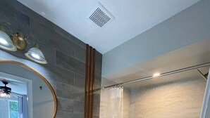 Ein modernes Badezimmer mit Waschbecken, Toilette und Dusche, alles in Weiß.