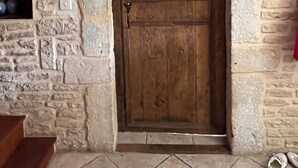 A rustic stone wall with a wooden door and a shelf with decorative items. - Tranquil House with large pool, set in beautiful private garden. separate Gite (Paizay-le-Chapt)
