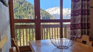 Ein Holzespeisekammer mit einer Metallschale als Mittelpunkt, ein Holzsessel und ein Blick auf eine Berglandschaft durch große Fenster.