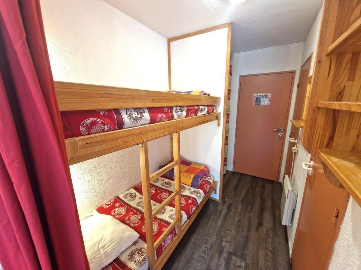A small, compact room with bunk beds and a wooden wardrobe.