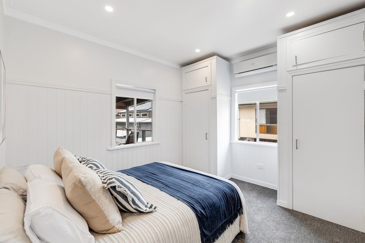 Quarto com cama, janela, espaço de armazenamento embutido e guarda-roupa.