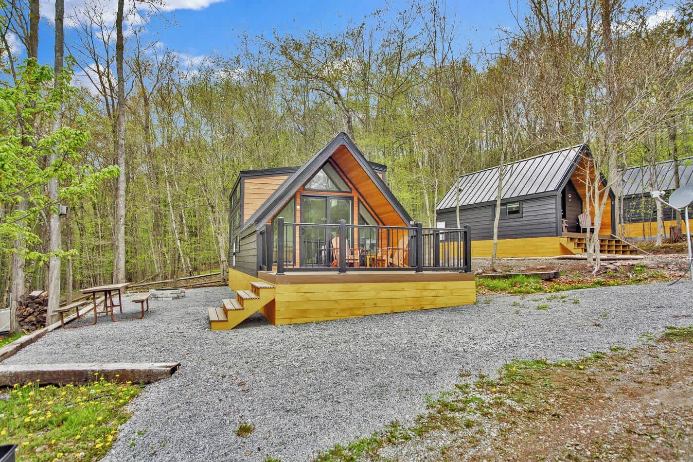 Eine Holzhütte mit einer Holzdiele, einem Glastür-Eingang und einem Metalldach.