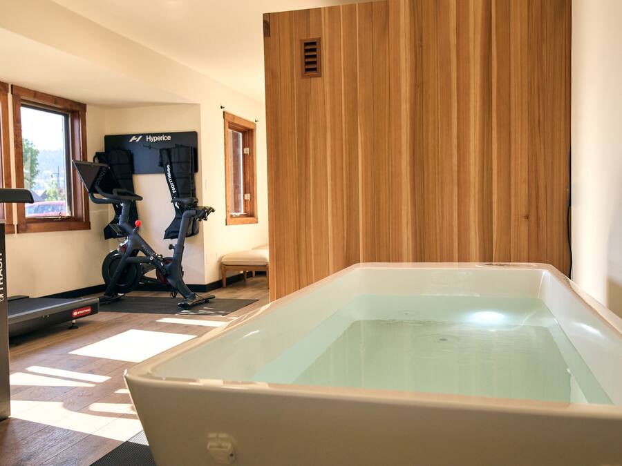 A room with a large bathtub, exercise equipment, and a window with a view.