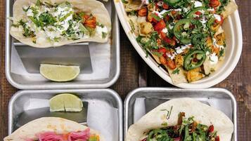 Un vassoio con quattro tipi diversi di tacos, ognuno guarnito in modo particolare.