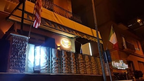 A hotel with a balcony, a sign reading "Hotel", and a flag. - Hotel Taromy  (Naples)