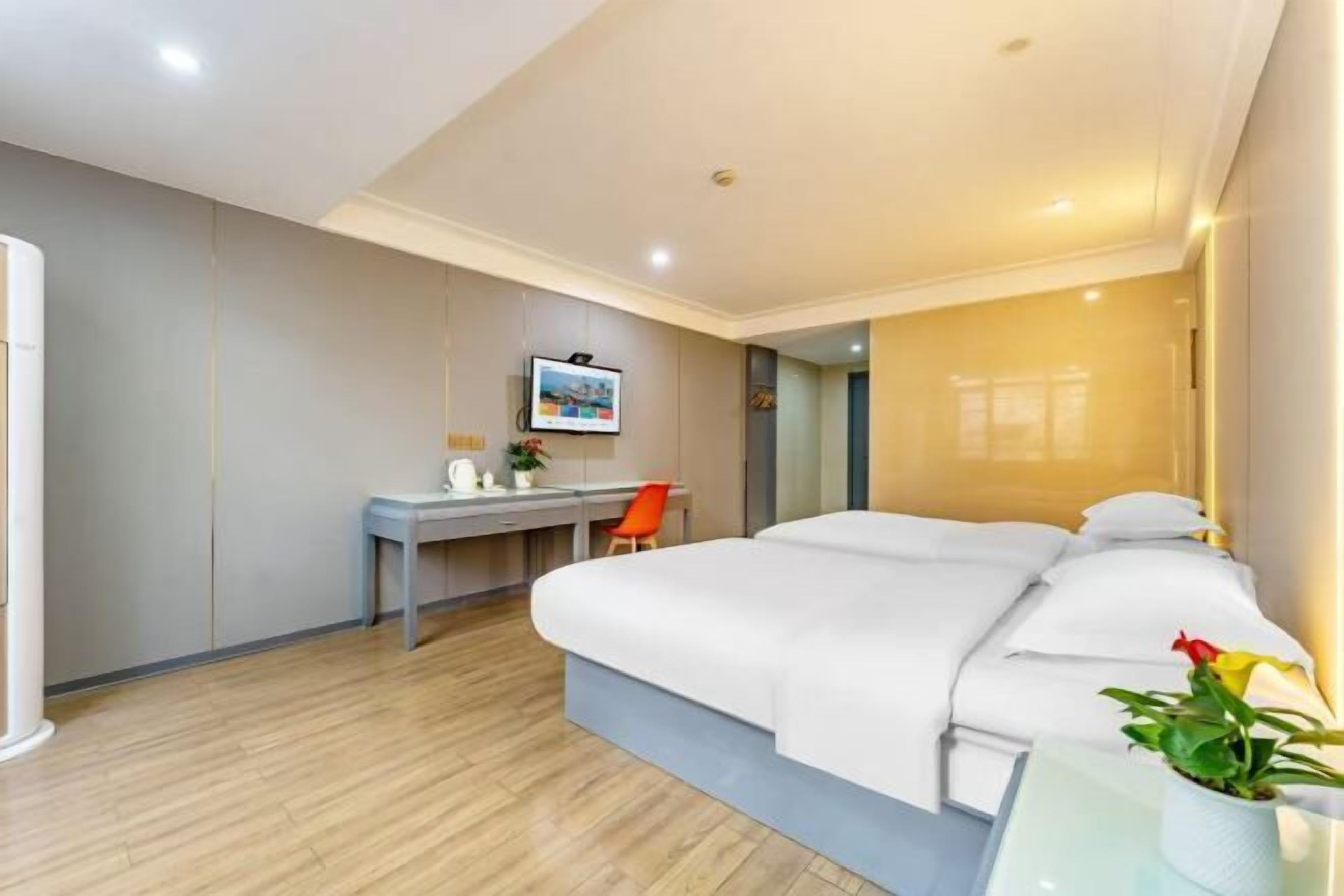 A modern hotel room with a bed, a desk, and a chair.