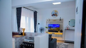 Una cocina moderna con estufa a gas, horno y un televisor de pantalla plana sobre el mostrador.