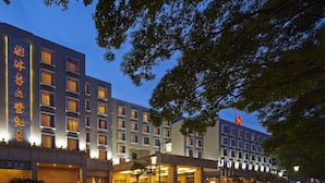 Un hotel con varios pisos, una entrada destacada y una fachada bien iluminada.