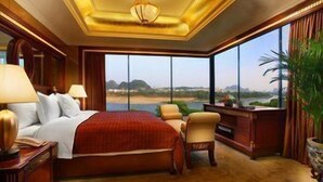 Habitación de hotel con una cama grande, un escritorio, una silla y vistas a un paisaje.