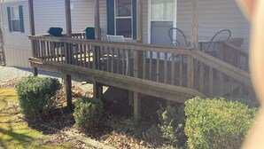 Une maison de plain-pied dotée d’une terrasse en bois et d’un porche couvert.