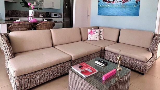 A living room with a sectional sofa, a coffee table, and a ceiling fan.