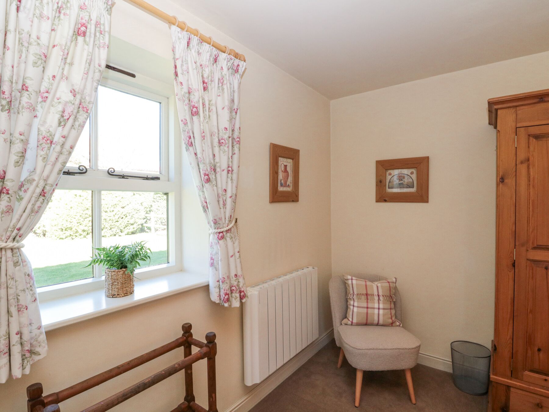 A room with a window, a radiator, a chair, and a wooden door.