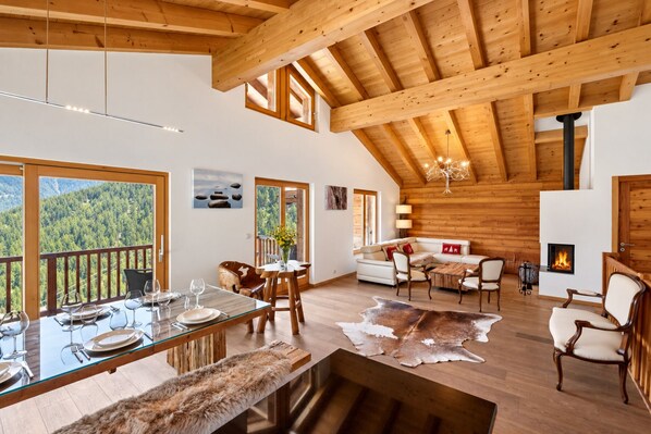 Una habitación amplia con zona de comedor, un conjunto de sofás y una chimenea.