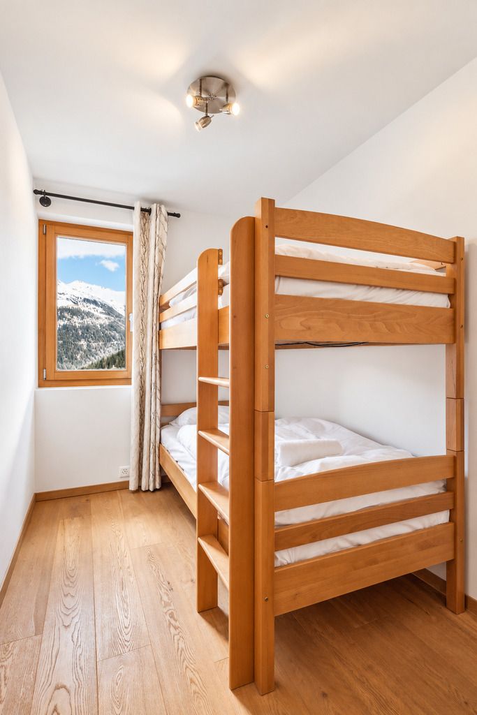 Ein Schlafraum mit Etagenbett und Fenster mit Blick auf die Berge.
