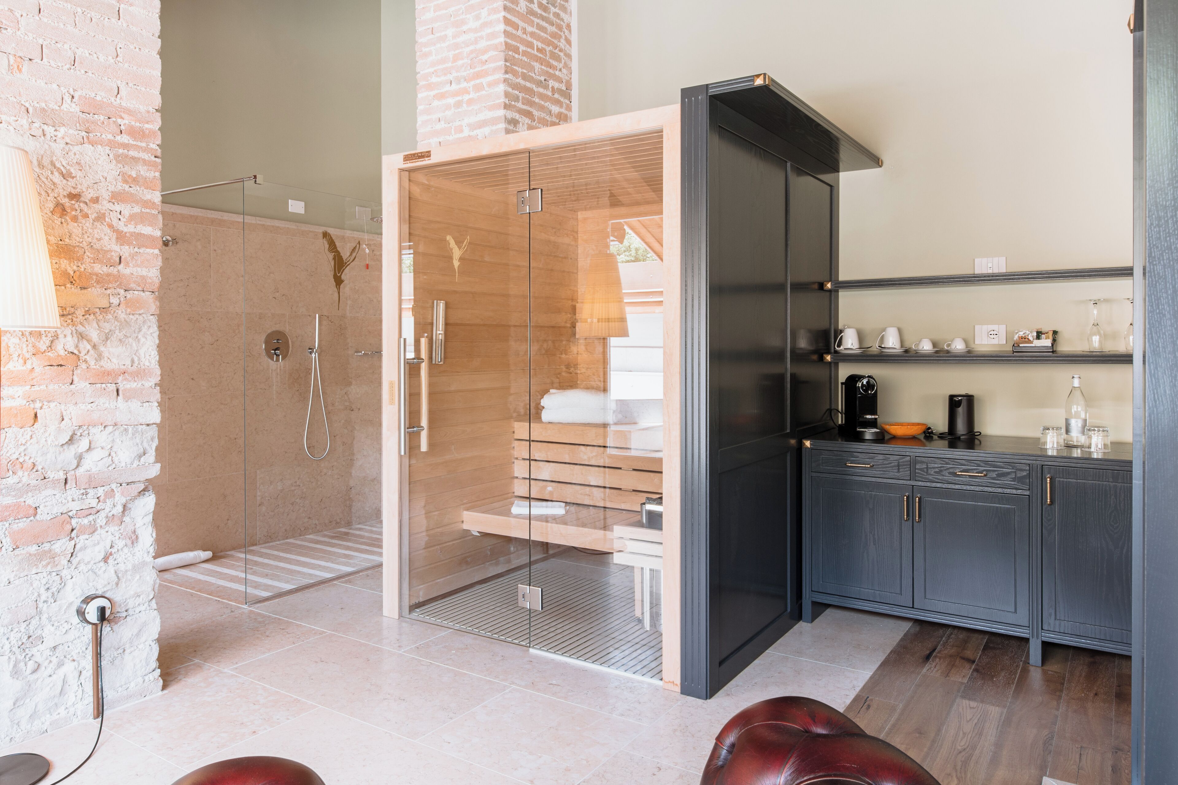 Une salle de bain moderne dotée d’une douche à parois de verre, d’un meuble-lavabo en bois et d’un sauna intégré.