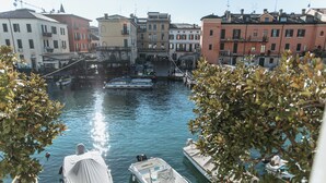 A canal with boats docked, surrounded by historic buildings. - Pavillon Suite (Peschiera del Garda)