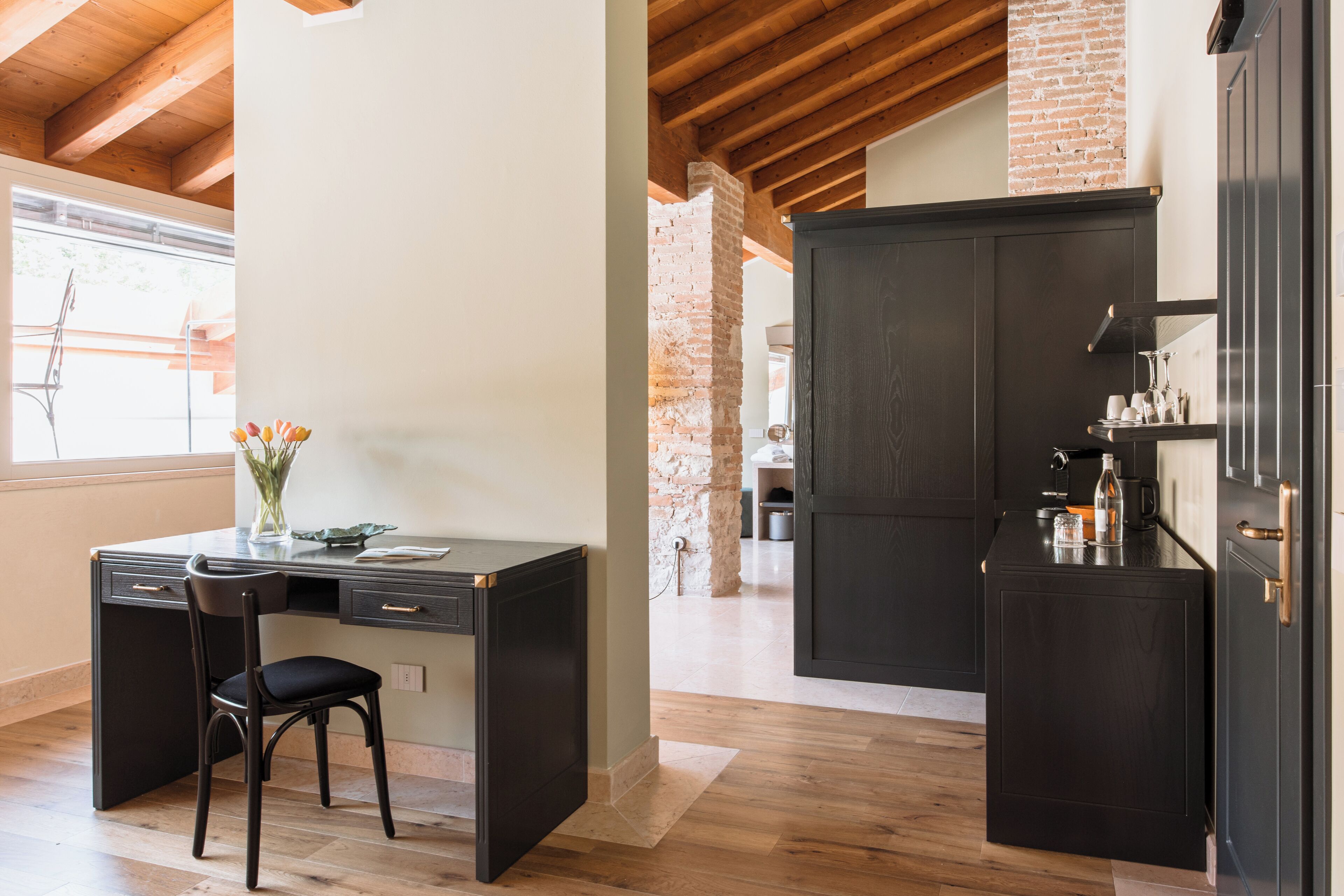 A modern kitchen with dark cabinetry, a wooden dining table, and a chair.