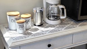 A kitchen counter with a coffee maker, a kettle, and containers labeled with coffee, sugar, and tea. - Private cottage close to SoFi, FiFa fans welcome! (Long Beach)