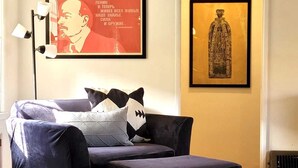 A living room with a dark blue sofa, a patterned rug, and two framed artworks on the wall. - Private cottage close to SoFi, FiFa fans welcome! (Long Beach)